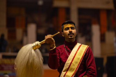 Varanasi, Uttar Pradesh, Hindistan - 18 Ocak 2024: Ganga aarti, Genç erkek rahibin portresi Dashashwamedh ghat 'ta kutsal nehir ganges akşam aarti gösterisi Hindu ayinleri ile geleneksel elbise. 