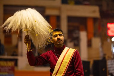 Varanasi, Uttar Pradesh, Hindistan - 18 Ocak 2024: Ganga aarti, Genç erkek rahibin portresi Dashashwamedh ghat 'ta kutsal nehir ganges akşam aarti gösterisi Hindu ayinleri ile geleneksel elbise. 