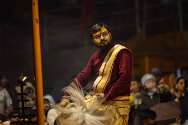 Varanasi, Uttar Pradesh, Hindistan - 18 Ocak 2024: Ganga aarti, Genç erkek rahibin portresi Dashashwamedh ghat 'ta kutsal nehir ganges akşam aarti gösterisi Hindu ayinleri ile geleneksel elbise. 