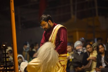 Varanasi, Uttar Pradesh, Hindistan - 18 Ocak 2024: Ganga aarti, Genç erkek rahibin portresi Dashashwamedh ghat 'ta kutsal nehir ganges akşam aarti gösterisi Hindu ayinleri ile geleneksel elbise. 