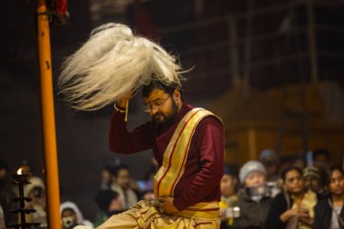 Varanasi, Uttar Pradesh, Hindistan - 18 Ocak 2024: Ganga aarti, Genç erkek rahibin portresi Dashashwamedh ghat 'ta kutsal nehir ganges akşam aarti gösterisi Hindu ayinleri ile geleneksel elbise. 