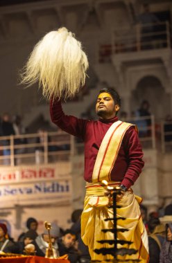 Varanasi, Uttar Pradesh, Hindistan - 18 Ocak 2024: Ganga aarti, Genç erkek rahibin portresi Dashashwamedh ghat 'ta kutsal nehir ganges akşam aarti gösterisi Hindu ayinleri ile geleneksel elbise. 