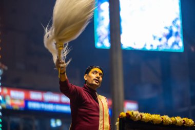 Varanasi, Uttar Pradesh, Hindistan - 18 Ocak 2024: Ganga aarti, Genç erkek rahibin portresi Dashashwamedh ghat 'ta kutsal nehir ganges akşam aarti gösterisi Hindu ayinleri ile geleneksel elbise. 