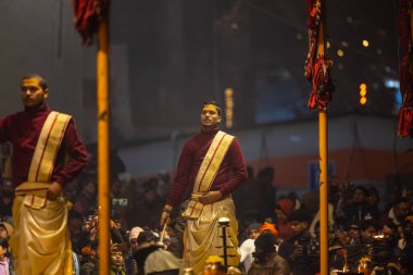 Varanasi, Uttar Pradesh, Hindistan - 18 Ocak 2024: Ganga aarti, Genç erkek rahibin portresi Dashashwamedh ghat 'ta kutsal nehir ganges akşam aarti gösterisi Hindu ayinleri ile geleneksel elbise. 