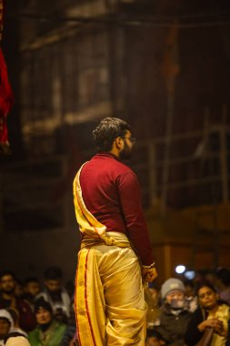 Varanasi, Uttar Pradesh, Hindistan - 18 Ocak 2024: Ganga aarti, Genç erkek rahibin portresi Dashashwamedh ghat 'ta kutsal nehir ganges akşam aarti gösterisi Hindu ayinleri ile geleneksel elbise. 