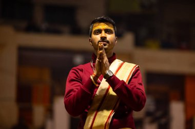 Varanasi, Uttar Pradesh, Hindistan - 18 Ocak 2024: Ganga aarti, Genç erkek rahibin portresi Dashashwamedh ghat 'ta kutsal nehir ganges akşam aarti gösterisi Hindu ayinleri ile geleneksel elbise. 