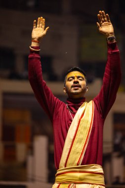 Varanasi, Uttar Pradesh, Hindistan - 18 Ocak 2024: Ganga aarti, Genç erkek rahibin portresi Dashashwamedh ghat 'ta kutsal nehir ganges akşam aarti gösterisi Hindu ayinleri ile geleneksel elbise. 