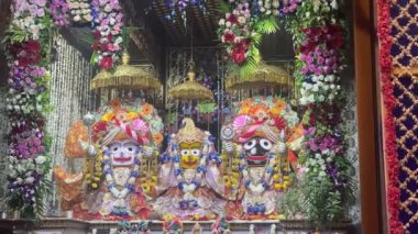 Vrindavan, Uttar Pradesh, Hindistan - 4 Temmuz 2024: Hindu tanrısı Krishna ve tanrıça Radha 'nın Isckon tapınağında renkli çiçekler ve kıyafetlerle süslenmiş heykeli.