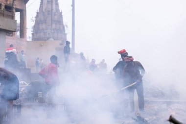 Varanasi, Uttar Pradesh, Hindistan - 18 Ocak 2024: Hintli bir erkek işçinin portresi yanmış kemikleri toplamak ve cesetleri hindu ayini olarak manikarnika ghat 'ta yakmak için yer açmak