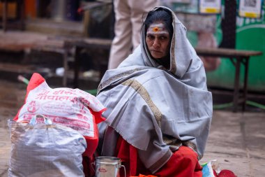 Varanasi, Uttar Pradesh, Hindistan - 05 Mart 2023: Varanasi 'deki çetelerin yakınındaki ghatlarda geleneksel giysiler giyen insanlar.