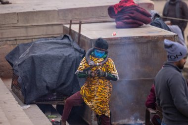 Varanasi, Uttar Pradesh, Hindistan - 18 Ocak 2024: Varanasi 'deki çetelerin yakınındaki ghat' larda yaşayan insanlar. Sadhu, Kaşhi 'de Ganga yakınlarında meditasyon yapıyor..