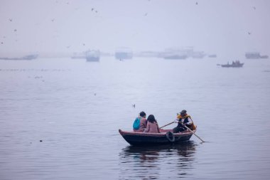 Varanasi, Uttar Pradesh, Hindistan - 05 Mart 2023: Varanasi 'deki çetelerin yakınındaki ghatlarda geleneksel giysiler giyen insanlar.