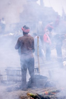 Varanasi, Uttar Pradesh, Hindistan - 18 Ocak 2024: Hintli bir erkek işçinin portresi yanmış kemikleri toplamak ve cesetleri hindu ayini olarak manikarnika ghat 'ta yakmak için yer açmak