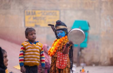 Varanasi, Uttar Pradesh, Hindistan - 18 Ocak 2024: Varanasi 'deki çetelerin yakınındaki ghat' larda yaşayan insanlar. Sadhu, Kaşhi 'de Ganga yakınlarında meditasyon yapıyor..