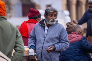 Varanasi, Uttar Pradesh, Hindistan - 05 Mart 2023: Varanasi 'deki çetelerin yakınındaki ghatlarda geleneksel giysiler giyen insanlar.