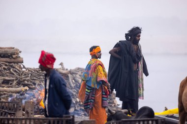 Varanasi, Uttar Pradesh, Hindistan - 18 Ocak 2024: Varanasi 'deki çetelerin yakınındaki ghat' larda yaşayan insanlar. Sadhu, Kaşhi 'de Ganga yakınlarında meditasyon yapıyor..