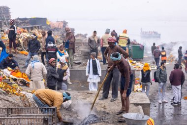 Varanasi, Uttar Pradesh, Hindistan - 18 Ocak 2024: Varanasi 'deki çetelerin yakınındaki ghat' larda yaşayan insanlar. Sadhu, Kaşhi 'de Ganga yakınlarında meditasyon yapıyor..