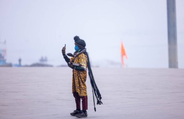 Varanasi, Uttar Pradesh, Hindistan - 18 Ocak 2024: Varanasi 'deki çetelerin yakınındaki ghat' larda yaşayan insanlar. Sadhu, Kaşhi 'de Ganga yakınlarında meditasyon yapıyor..