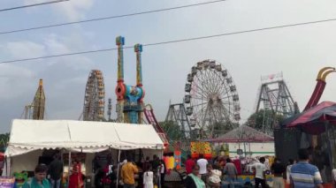 Yeni Delhi, Hindistan - 14 Eylül 2024: Yıllık fuar sırasında mavi gökyüzünün altında dönen dönme dolap videosu.