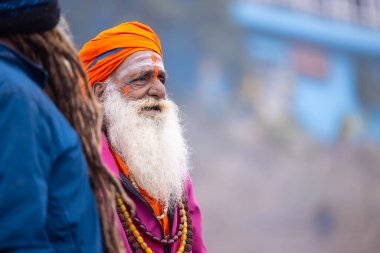 Varanasi, Uttar Pradesh, Hindistan - 18 Ocak 2024: Varanasi 'deki çetelerin yakınındaki ghatlarda yürüyen geleneksel sadhu baba resmi. Sadhu, Kaşhi 'de Ganga yakınlarında meditasyon yapıyor.