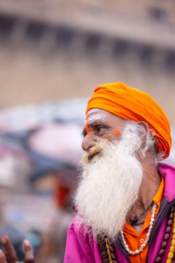 Varanasi, Uttar Pradesh, Hindistan - 18 Ocak 2024: Varanasi 'deki çetelerin yakınındaki ghatlarda yürüyen geleneksel sadhu baba resmi. Sadhu, Kaşhi 'de Ganga yakınlarında meditasyon yapıyor.