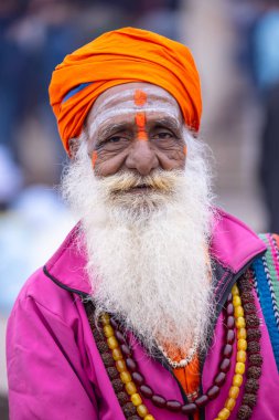 Varanasi, Uttar Pradesh, Hindistan - 18 Ocak 2024: Varanasi 'deki çetelerin yakınındaki ghatlarda yürüyen geleneksel sadhu baba resmi. Sadhu, Kaşhi 'de Ganga yakınlarında meditasyon yapıyor.