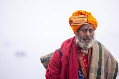 Varanasi, Uttar Pradesh, Hindistan - 18 Ocak 2024: Varanasi 'deki çetelerin yakınındaki ghatlarda yürüyen geleneksel sadhu baba resmi. Sadhu, Kaşhi 'de Ganga yakınlarında meditasyon yapıyor.