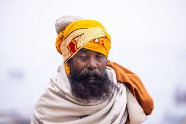 Varanasi, Uttar Pradesh, Hindistan - 18 Ocak 2024: Varanasi 'deki çetelerin yakınındaki ghatlarda yürüyen geleneksel sadhu baba resmi. Sadhu, Kaşhi 'de Ganga yakınlarında meditasyon yapıyor.