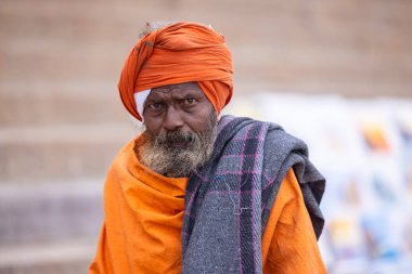 Varanasi, Uttar Pradesh, Hindistan - 18 Ocak 2024: Varanasi 'deki çetelerin yakınındaki ghatlarda yürüyen geleneksel sadhu baba resmi. Sadhu, Kaşhi 'de Ganga yakınlarında meditasyon yapıyor.