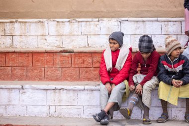 Varanasi, Uttar Pradesh, India - January 18 2024: Group of an young students of gurukul or school at ghats of holy river ganga in varanasi during winter morning. clipart