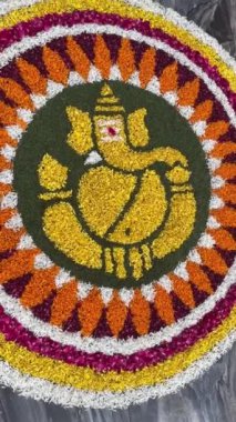 Ganesh Chaturthi Festivali sırasında yere çiçek serilmiş hindu tanrısı Ganesh 'in el yapımı Rangoli' si..