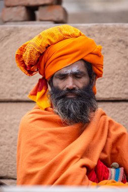 Varanasi, Uttar Pradesh, Hindistan - 18 Ocak 2024: Chlam veya puro içen yaşlı bir erkek sadhu 'nun portresi.