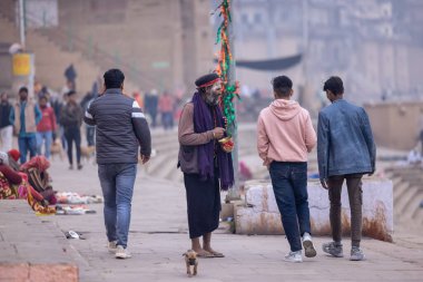 Varanasi, Uttar Pradesh, Hindistan - 18 Ocak 2024: Varanasi 'deki çetelerin yakınındaki ghat' larda yaşayan insanlar. Sadhu, Kaşhi 'de Ganga yakınlarında meditasyon yapıyor..