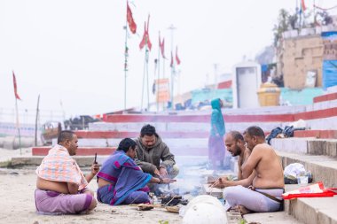 Varanasi, Uttar Pradesh, India - January 18 2024: brahmin south indian people performing shraadh rituals at kedar ghat under the supervision of priest near river ganges in varanasi. clipart