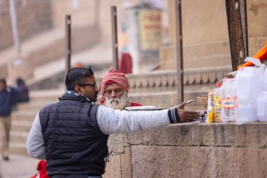 Varanasi, Uttar Pradesh, Hindistan - 18 Ocak 2024: Varanasi 'deki çetelerin yakınındaki ghat' larda yaşayan insanlar. Sadhu, Kaşhi 'de Ganga yakınlarında meditasyon yapıyor..