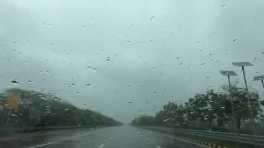 Muson yağmurları ve otoyollarda hareket halindeki arabanın camına damlacıklar yağdı..