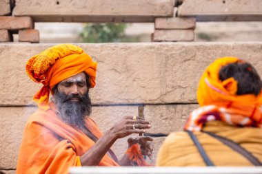 Varanasi, Uttar Pradesh, Hindistan - 18 Ocak 2024: Chlam veya puro içen yaşlı bir erkek sadhu 'nun portresi.