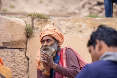 Varanasi, Uttar Pradesh, Hindistan - 18 Ocak 2024: Chlam veya puro içen yaşlı bir erkek sadhu 'nun portresi.