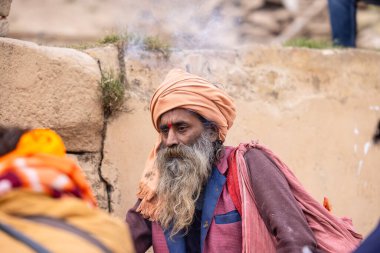 Varanasi, Uttar Pradesh, Hindistan - 18 Ocak 2024: Chlam veya puro içen yaşlı bir erkek sadhu 'nun portresi.