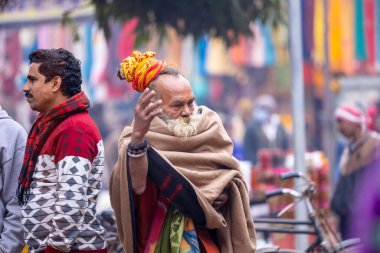Varanasi, Uttar Pradesh, Hindistan - 05 Mart 2023: Varanasi 'deki çetelerin yakınındaki ghatlarda geleneksel giysiler giyen insanlar.