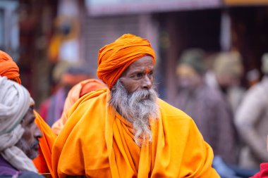 Varanasi, Uttar Pradesh, Hindistan - 18 Ocak 2024: Varanasi 'deki çetelerin yakınındaki ghatlarda yürüyen geleneksel sadhu baba resmi. Sadhu, Kaşhi 'de Ganga yakınlarında meditasyon yapıyor.