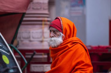 Varanasi, Uttar Pradesh, Hindistan - 18 Ocak 2024: Varanasi 'deki çetelerin yakınındaki ghatlarda yürüyen geleneksel sadhu baba resmi. Sadhu, Kaşhi 'de Ganga yakınlarında meditasyon yapıyor.