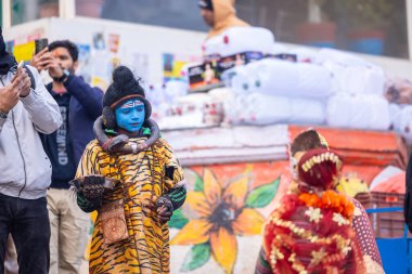 Varanasi, Uttar Pradesh, Hindistan - 18 Ocak 2024: Varanasi 'de nehir keneviri ghatları üzerinde duran insanlar.