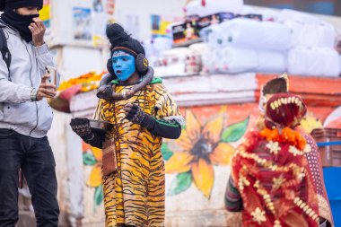 Varanasi, Uttar Pradesh, Hindistan - 18 Ocak 2024: Varanasi 'de nehir keneviri ghatları üzerinde duran insanlar.