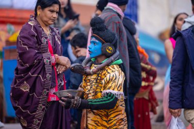 Varanasi, Uttar Pradesh, Hindistan - 18 Ocak 2024: Varanasi 'de nehir keneviri ghatları üzerinde duran insanlar.