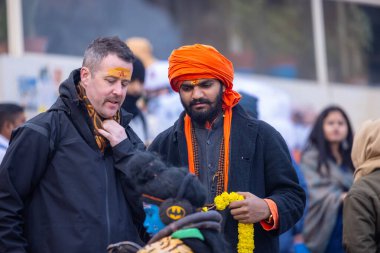 Varanasi, Uttar Pradesh, Hindistan - 18 Ocak 2024: Varanasi 'de nehir keneviri ghatları üzerinde duran insanlar.