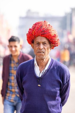 Puşkar, Rajasthan, Hindistan - 25 Kasım 2023: Puşkar Fuarı, Rajasthani 'li yaşlı bir erkeğin portresi geleneksel elbise ve renkli türbanlı bir adam.