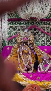 Vrindavan, Uttar Pradesh, Hindistan - 4 Temmuz 2024: Hindu tanrısı Krishna ve tanrıça Radha 'nın Isckon tapınağında renkli çiçekler ve kıyafetlerle süslenmiş heykeli.