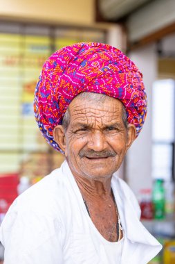 Puşkar, Rajasthan, Hindistan - 25 Kasım 2023: Puşkar Fuarı, Rajasthani 'li yaşlı bir erkeğin portresi geleneksel elbise ve renkli türbanlı bir adam.