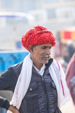 Puşkar, Rajasthan, Hindistan - 25 Kasım 2023: Puşkar Fuarı, Rajasthani 'li yaşlı bir erkeğin portresi geleneksel elbise ve renkli türbanlı bir adam.